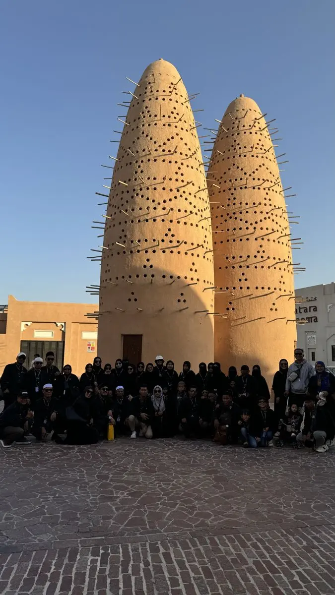 Rombongan jamaah berfoto di depan menara merpati Katara, Doha